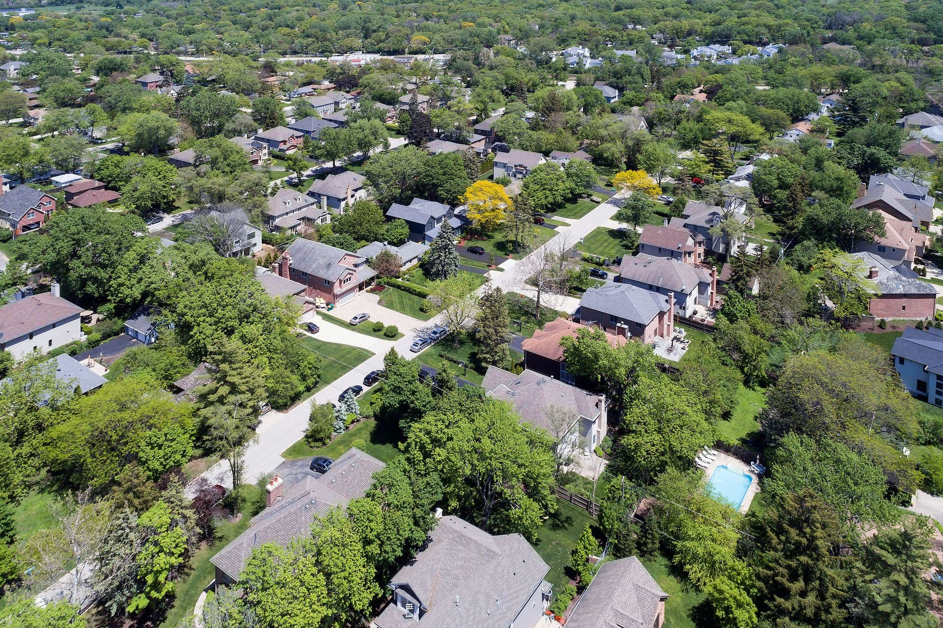 Aerial view of a neighborhood with mature trees in a Chicago suburban neighborhood in summer. Deefield, IL. USA
